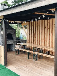 a picnic area with wooden tables and a fireplace at Зелена долина in Solgutovo