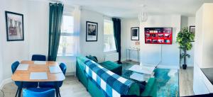 a living room with a blue couch and a table at Folkestone Harbour Modern Comfortable Flat F3 in Folkestone