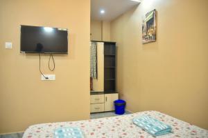 a bedroom with a bed and a tv on the wall at JFZ Homestay in Kāsarkod