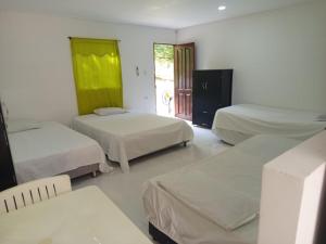 a room with three beds and a door to a patio at Apartaestudio la Ísla in Estación El Salto