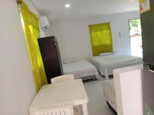 a room with two beds and a table and chairs at Apartaestudio la Ísla in Estación El Salto