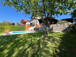 a tree in a yard next to a house at Villa Otto - Private Pool & Garden in Zagreb