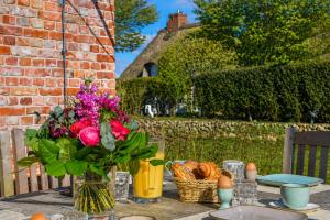 a table with a vase of flowers and bread on it at Haus Lang Libben in Archsum