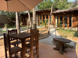 a table and chairs and a table and an umbrella at Straw hat suites La punta in Santa María Colotepec
