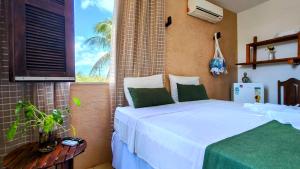 a bedroom with a white bed and a window at Casa Mandacaru Pousada in Cumbuco +58 photos