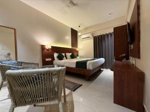 a hotel room with a bed and a television at RJ14 Accommodations at Baga Beach in Baga