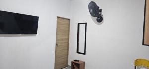 a room with a flat screen tv on a white wall at Tierra Dulce - Casa Turística in Villeta
