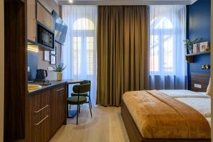 a hotel room with a bed and a desk and a sink at Budapest Holidays Storia in Budapest