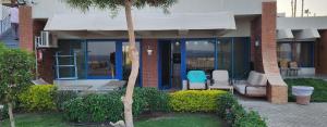 a house with two chairs and a palm tree at Cosy Romantic Sea View Villa at a 5 Hotel in Sharm El Sheikh