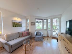 a living room with a couch and a tv at Seegarten Apartment 4 in Hagnau