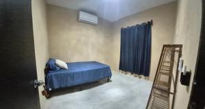 ein Schlafzimmer mit einem Bett mit blauen Laken und einer Leiter in der Unterkunft Casa Haema in El Cuyo