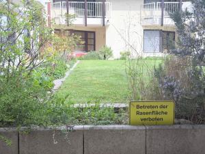 a sign in front of a house with a yard at Seegarten Apartment 4 in Hagnau