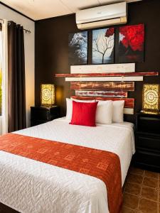 a bedroom with a large bed with a red pillow at Casa Olas in Quepos