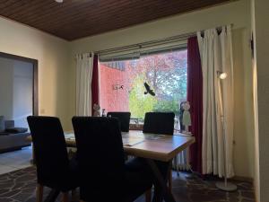 a dining room table with chairs and a large window at Apartment Manderscheid near Castle Ruins in Manderscheid