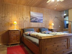 a bedroom with a large wooden bed with two lamps at Apartment Manderscheid near Castle Ruins in Manderscheid +19 photos