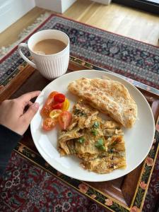 a plate of food and a cup of coffee and a plate of food at Hotel Araamish in Peshawar