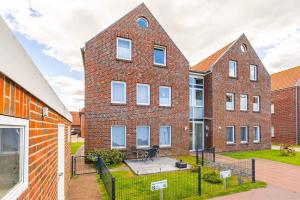 a brick building with a patio in front of it at Jantje in Norddeich