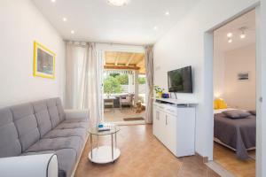 a living room with a couch and a bed and a television at House Lila Jacuzzy in Drvenik Mali
