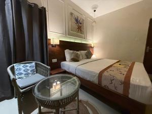 a bedroom with a bed and a table and a chair at RJ14 Accommodations at Baga Beach in Baga