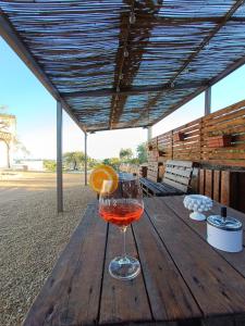 a wine glass with an orange on a wooden table at Borghetto Meti in Avola