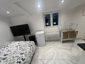 a bedroom with a bed and a television in a room at Maison Inviduelle in Aulnay-sous-Bois