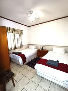 a bedroom with two beds and a ceiling fan at Pecan Cottage 2 in Machadodorp