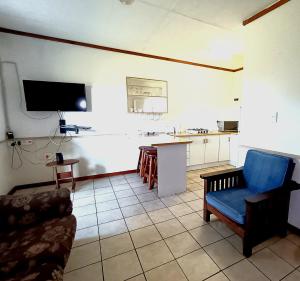 a living room with a couch and a tv and a kitchen at Pecan Cottage 2 in Machadodorp