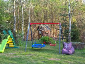 a group of playground equipment in a yard at Forest Sulimówka - dom na wyłączność z dala od sąsiadów in Ruda Kameralna