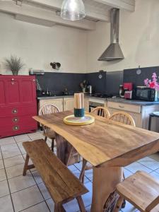 a kitchen with a wooden table and wooden chairs at Manoir des Nobles Cœurs et Spa in Saint-Donan