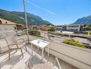 a balcony with a table and chairs and a view of a city at Hotel Villa Clara in Nago-Torbole