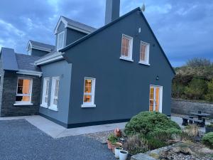 a blue house with a gravel driveway at Wild Atlantic Hideaway in Doolin