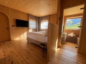 a bedroom with a bed and a large window at Garnì Lilly in San Lorenzo in Banale