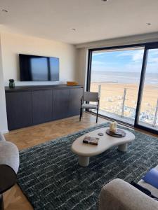 a living room with a tv and a coffee table at Knokke Sea, Appartement Vue mer in Knokke-Heist