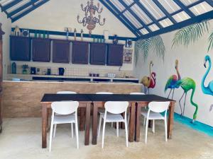 a kitchen with a table and chairs with flamingos painted on the wall at Casa Amalia - Jan Thiel Beach in Willemstad