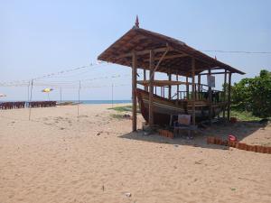 a wooden hut on a beach with the ocean at Dolphin beach in Varkala