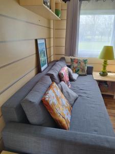 a large gray couch in a room with a window at Chez François in Crouay