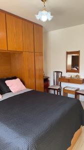 a bedroom with a large bed with a wooden headboard at Ap Centro - Wi-fi, Piscina, com Vista da Praça in Águas de Lindoia +53 photos