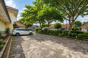 a car parked in a driveway of a house at Hotel Budi Famili Budget Syariah in Ciamis