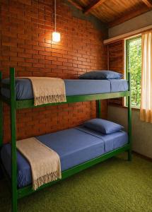 two bunk beds in a room with a brick wall at OlasHostel in Mendoza