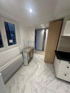 a kitchen with a white marble floor and a sink at Maison Individuelle in Aulnay-sous-Bois +3 photos