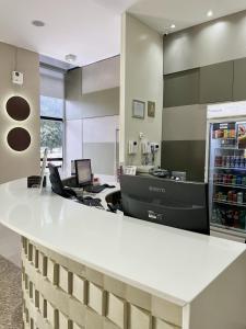 an office with a white counter and a refrigerator at Flat 315 - Comfort Hotel Taguatinga - Particular in Brasília