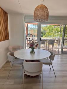 a dining room table with chairs and a vase of flowers at Spacious Private 2BR Guest Suite in Gold Coast