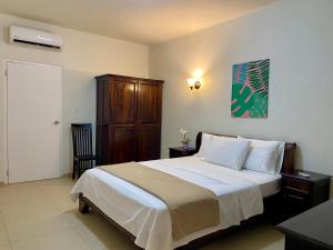 a bedroom with a large bed and a wooden cabinet at Casa Amalia - Jan Thiel Beach in Willemstad