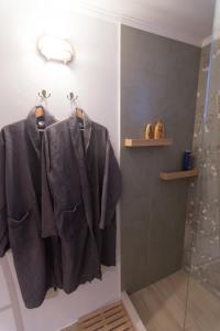 a bathroom with a shower withuits hanging on hooks at Almond Suite in Hydra