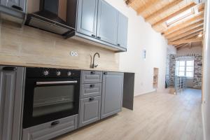 a kitchen with stainless steel appliances and wooden floors at Almond Suite in Hydra