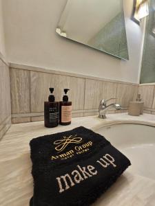 a bathroom sink with two bottles of soap on it at Arman Group in Athens +16 photos