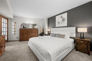 a bedroom with a large white bed and a dresser at 1777 Larimer 2211 in Denver