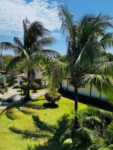 a group of palm trees in front of a building at Entre Palmas Venao in Playa Venao