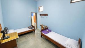 a room with three beds and a basketball hoop at Hotel Budi Famili Budget Syariah in Ciamis +2 photos