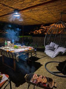 a table with a grill with food and a swing at Jemin Apartment in Berat